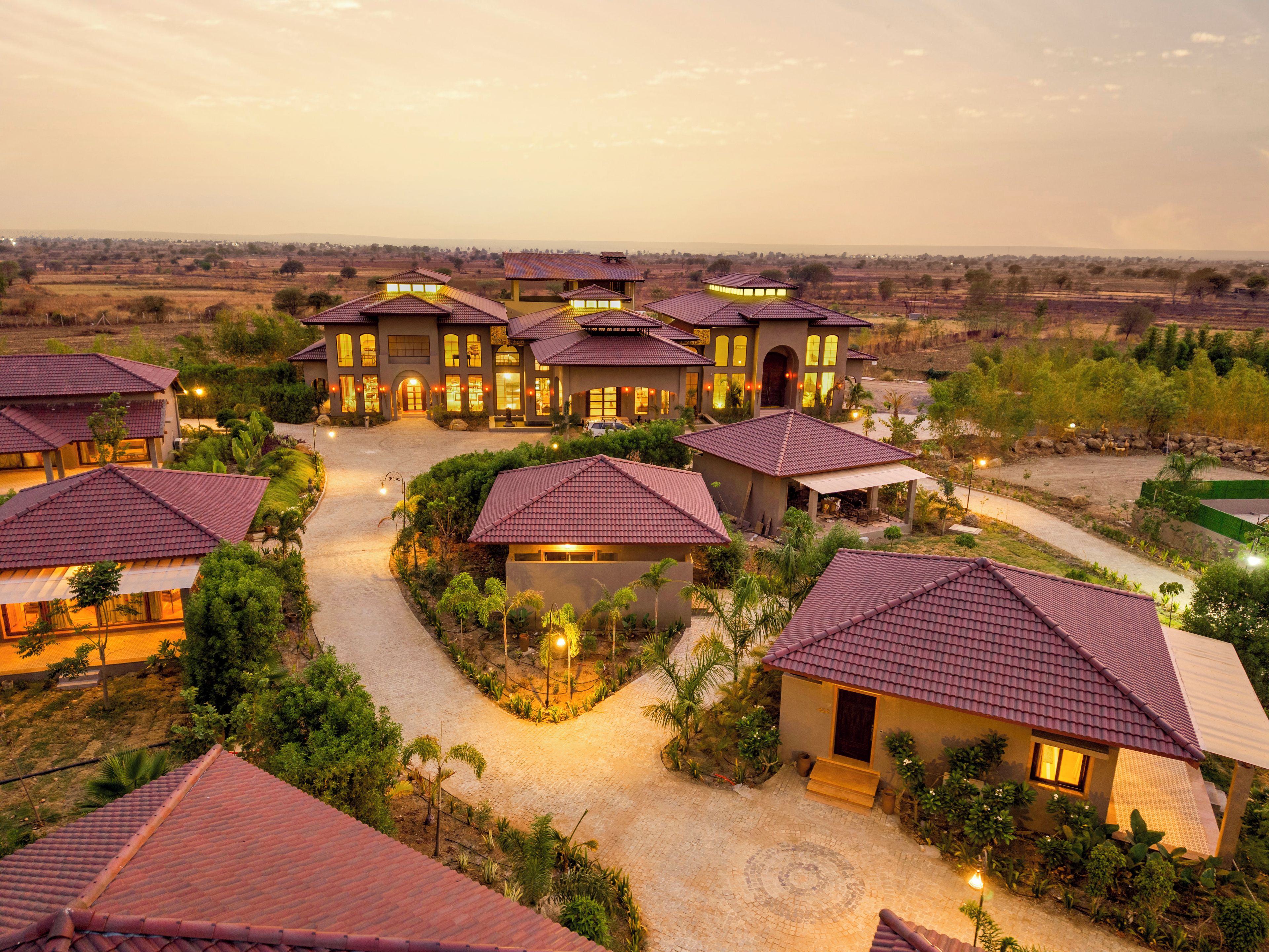 Un gran complejo turístico con múltiples villas, cada una con techo de tejas y un patio central.
