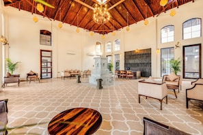 A spacious lobby with high ceilings, a central fountain, and seating areas.