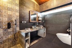 Casa de banho com chuveiro, sanita e lavatório.