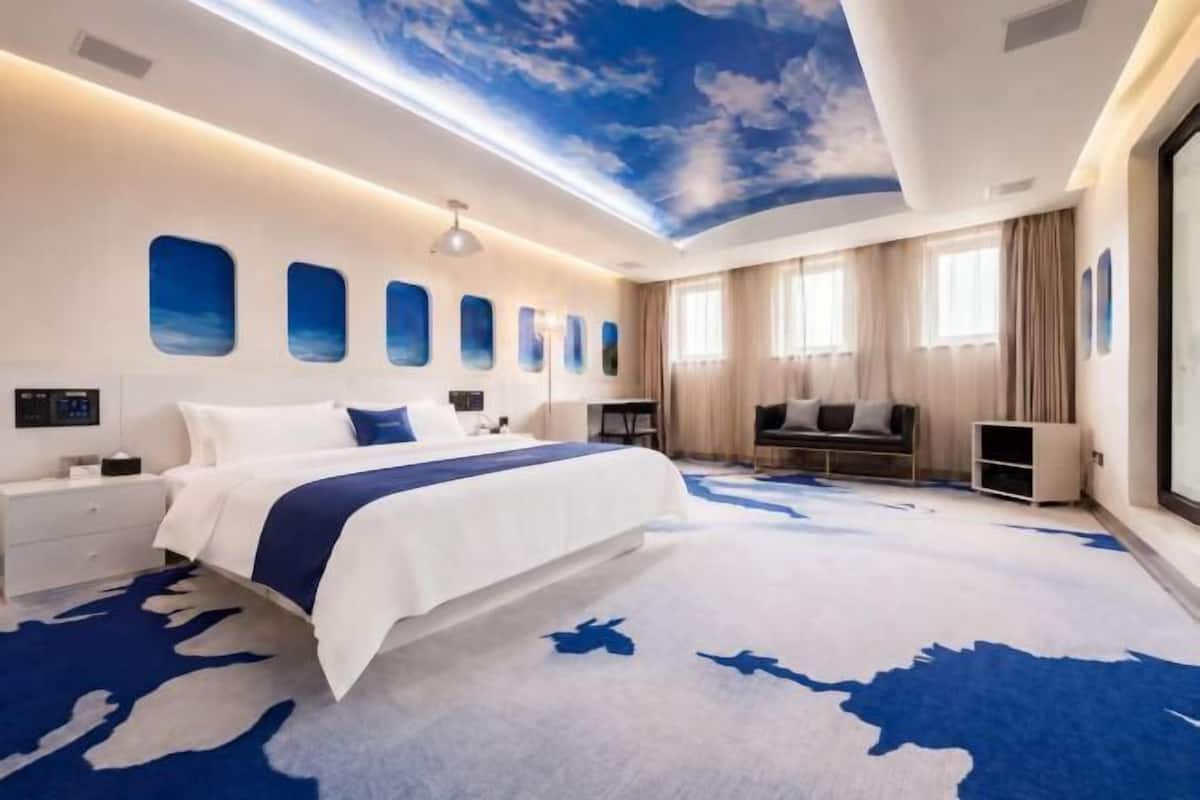 Un dormitorio moderno con una cama grande, un escritorio, una silla y un televisor.