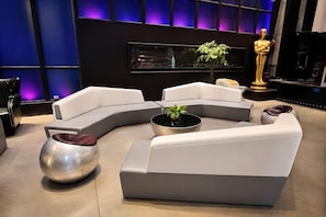A modern living room with a sectional sofa, a metallic coffee table, and a potted plant. - QING LAI IMAGE ART HOTEL Heda New District(YOUXI HOTEL) (Baoding)