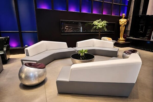 Un salon moderne avec un canapé d’angle, une table basse en métal et une plante en pot.