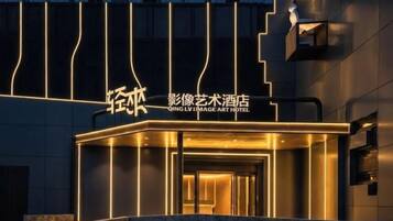 A hotel entrance with illuminated signage and a modern design.