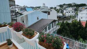 Un balcón con macetas y vistas a una zona residencial.