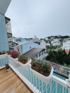 A balcony with potted plants and a view of a residential area. - An Tam House DaLat (Da Lat)