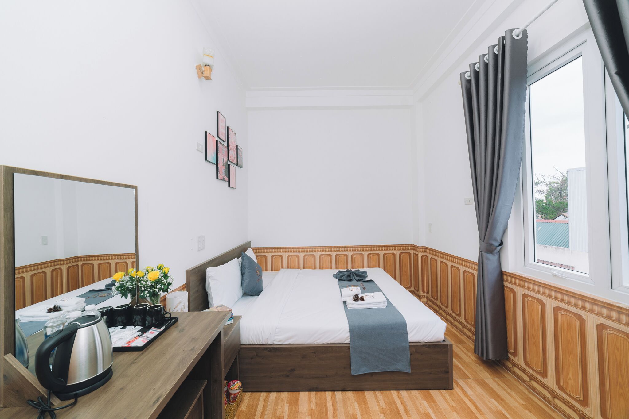 Ein Hotelzimmer mit Bett, Nachttisch, Spiegel und einem Fenster mit Vorhängen.
