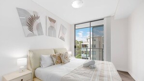 Una camera da letto con un letto, un comodino e un'opera d'arte appesa al muro.