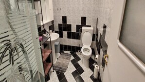 Ein Badezimmer mit Toilette, Waschbecken und Duschkabine.
