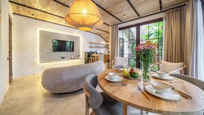 Uma sala de jantar moderna com uma mesa redonda, cadeiras e um pendente grande.