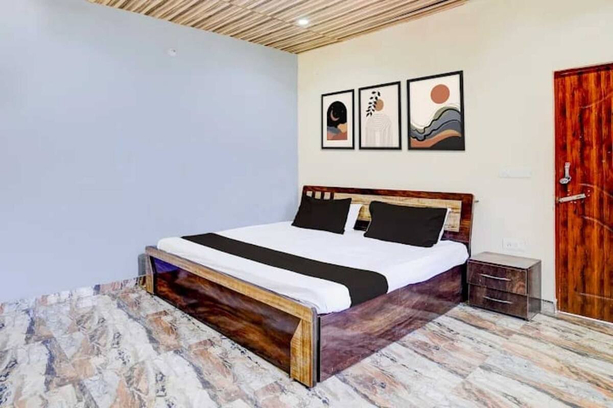 A bedroom with a wooden bed, a nightstand, and a wooden door.