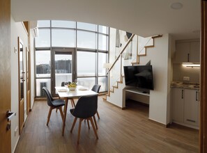 Ein modernes Interieur mit Essbereich, Fernseher und Treppe.