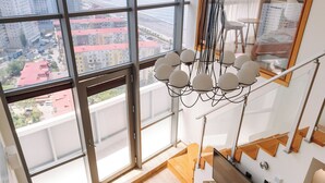 Eine moderne Wohnung mit Essbereich, einer Couch und einem großen Fenster mit Blick auf die Stadt.