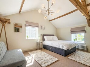 A bedroom with a bed, bedside tables, a floor lamp, and a window with a view. - 2 bedroom accommodation in Great Ayton (Great Ayton)
