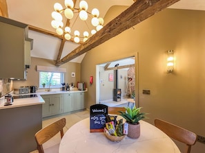 A modern kitchen with a central island, a dining area with a round table, and a cozy fireplace.