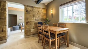 Un espace repas avec un mur en pierre, une table en bois et des chaises.
