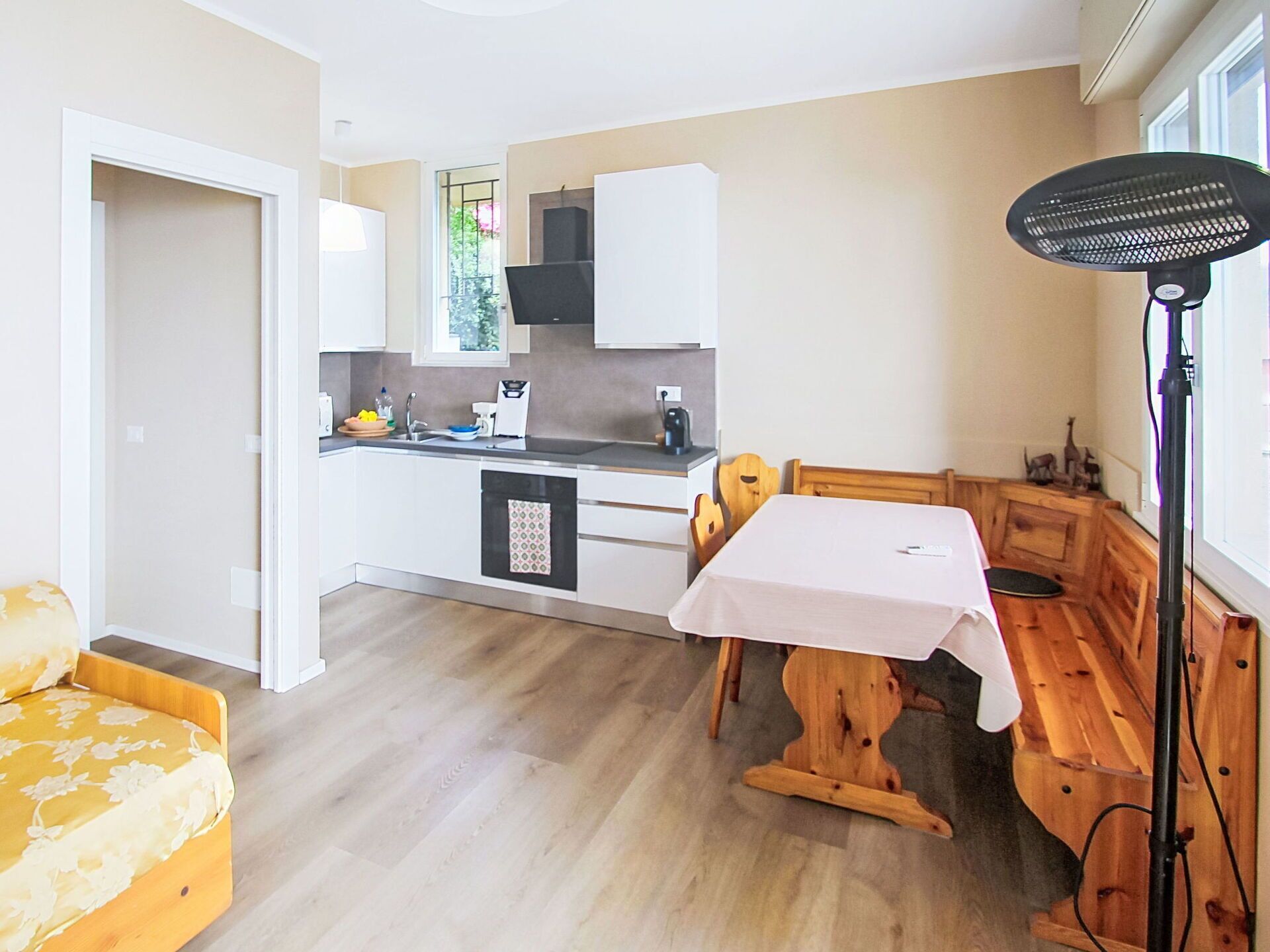 A compact kitchen with a dining area, a small table, and a fan.