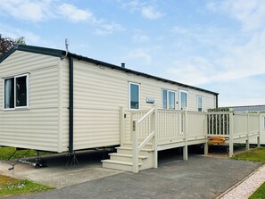 A single-story mobile home with a front deck and a staircase leading to the entrance. - 2 bedroom accommodation in Paignton (Paignton)