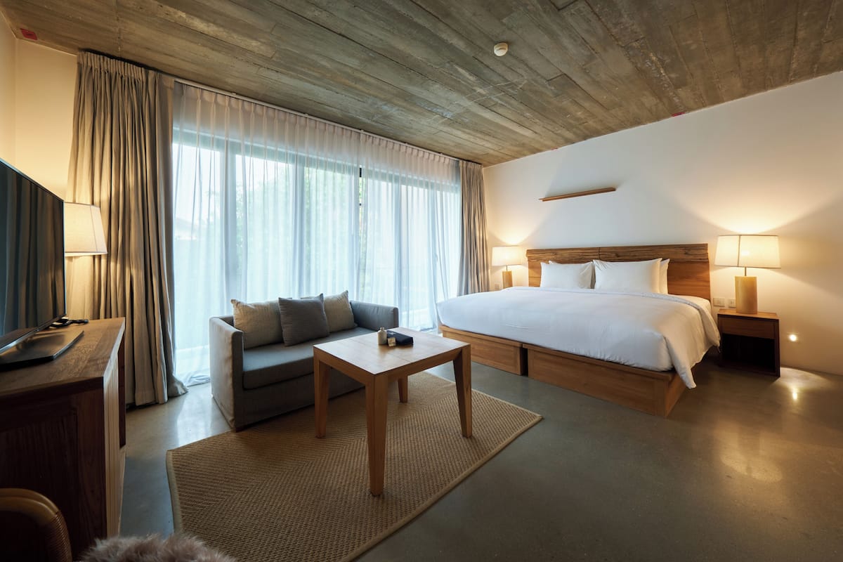 Ein Hotelzimmer mit Bett, einer Couch, einem Schreibtisch und einem kleinen Tisch.