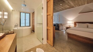 Un dormitorio moderno con una cama grande, ducha con mampara de vidrio y techo de madera.