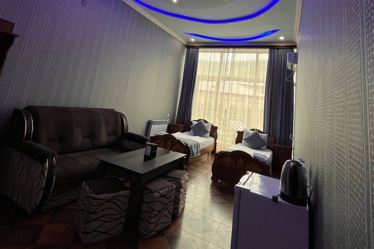 A modern living room with a sofa, a coffee table, and a bed.