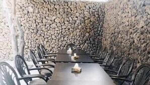 A long dining table with chairs, set against a stone wall. - ZANGEZUR HOTEL GORIS (Goris)