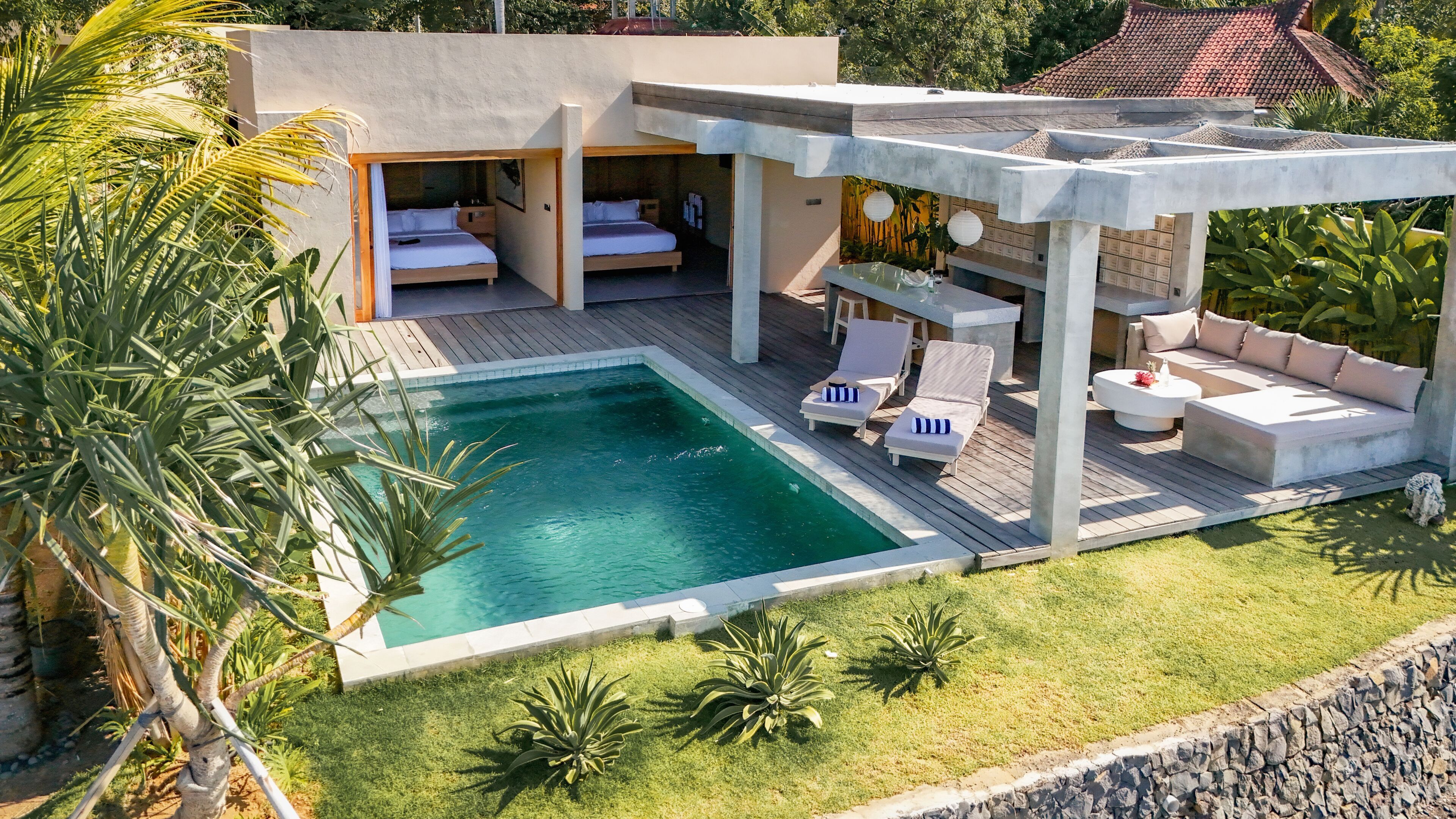 Eine moderne Villa mit Swimmingpool, Sitzgelegenheit im Freien und einem privaten Schlafzimmer.