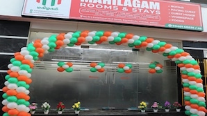 A hotel entrance with a red carpet and a balloon arch. - Mahilagam (Chennai)