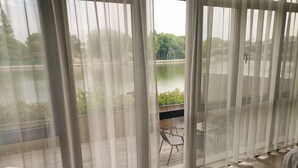 Una habitación con vistas a un lago, separada por cortinas traslúcidas.
