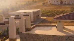 A courtyard with a central pavilion, surrounded by stone walls and a vineyard in the background. - Baja Toscana Private Wine CountryRetreat (Valle de Guadalupe)