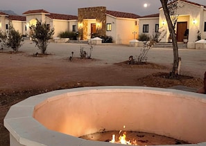 A courtyard with a fire pit, a stone building, and a tree. - Baja Toscana Private Wine CountryRetreat (Valle de Guadalupe)