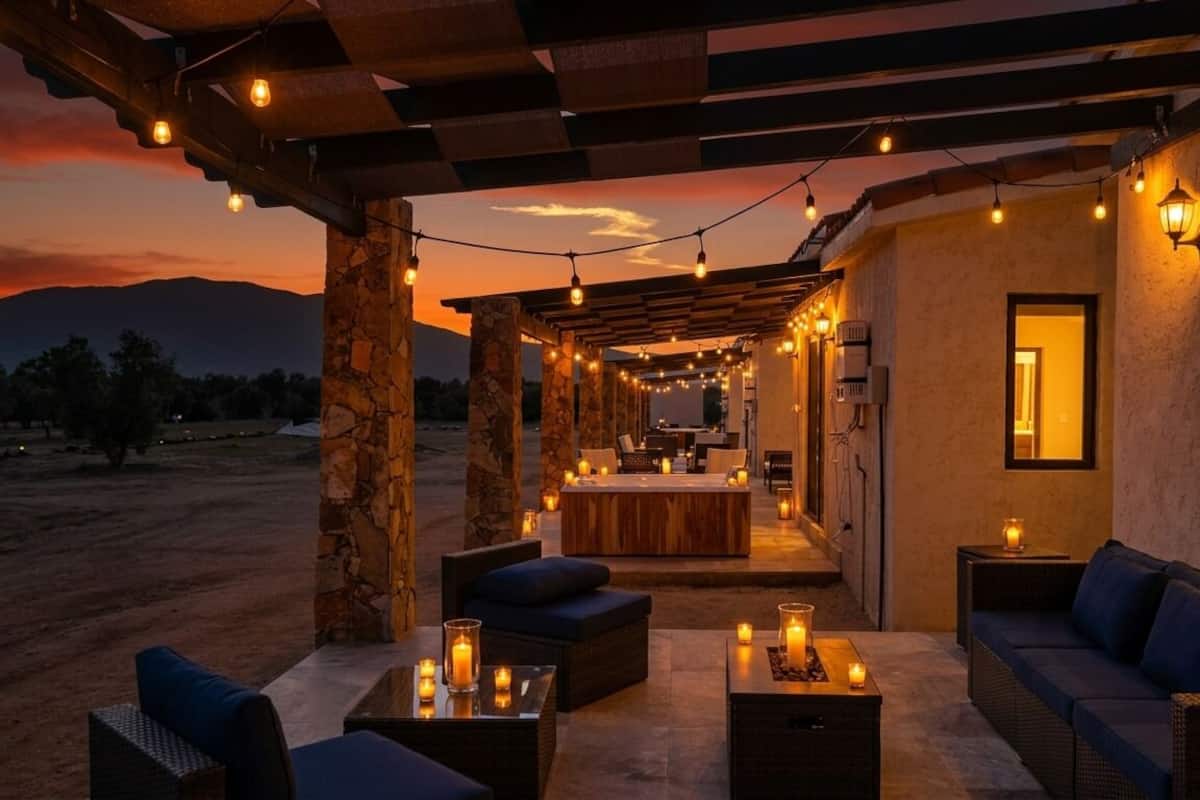 An outdoor patio area with seating, string lights, and candles.