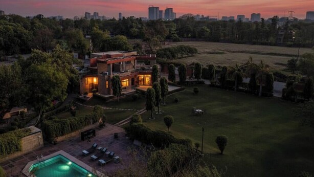 Una casa moderna con piscina, immersa nel verde e con lo skyline della città sullo sfondo.