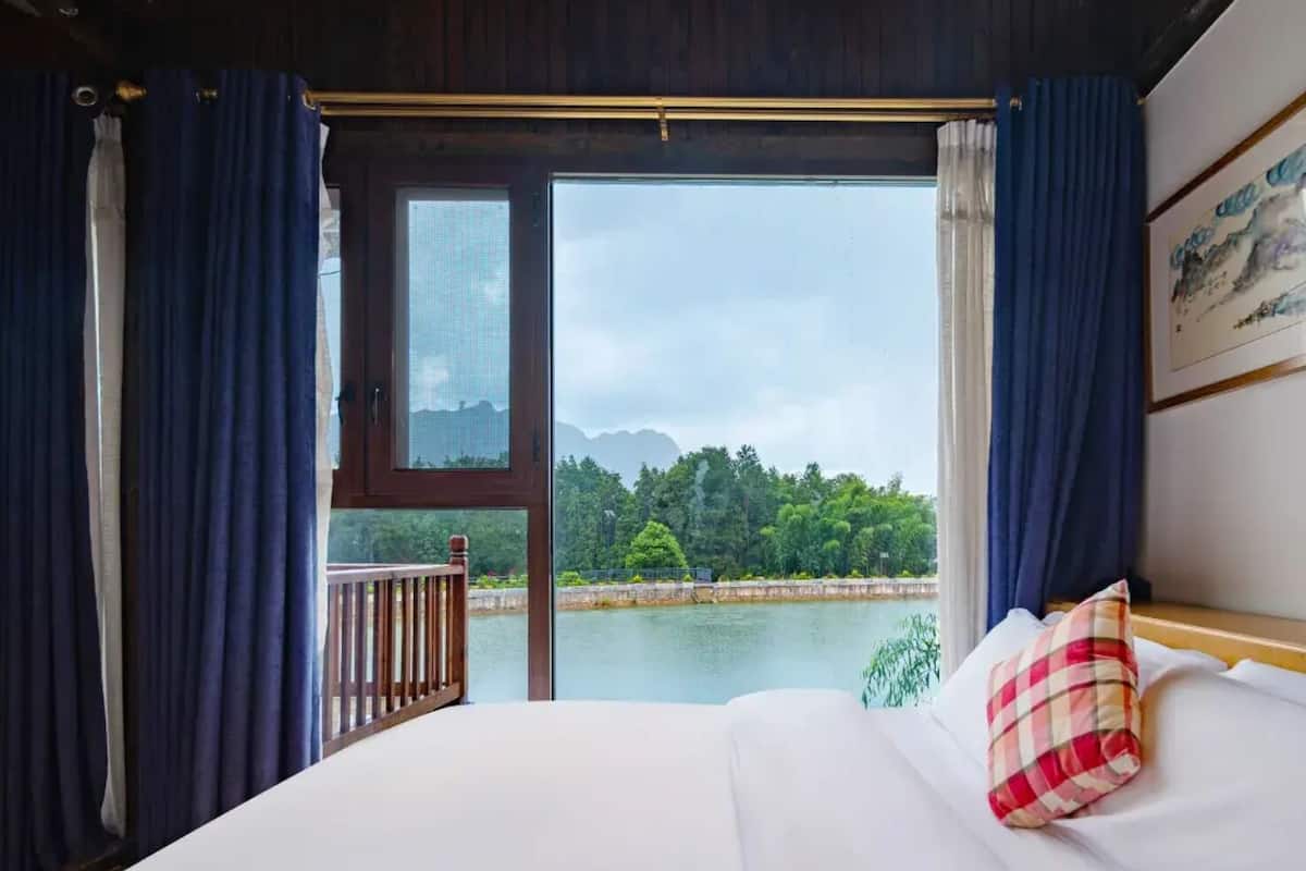 Una habitación con una cama, vistas a un lago y un balcón.