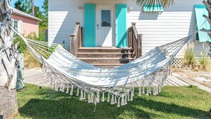 A white house with turquoise shutters and a hammock in front. - Rookery 3 family friendly pools beach dogs (Gulf Shores)