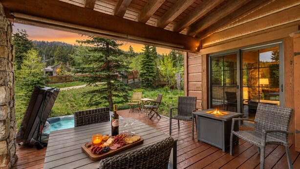 A wooden deck with outdoor seating, a hot tub, and a fire feature. - Luxury Tamarack Cottage | Ski-In/Ski-Out | Hot Tub | Walk to Village (Donnelly)