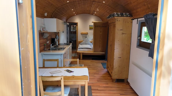 Una habitación pequeña con kitchenette, cama y ventana.