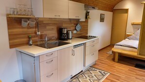 A compact kitchen with a sink, stove, and storage cabinets.