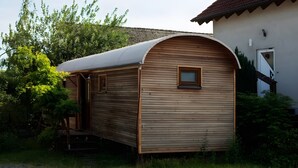 A small, single-story wooden structure with a curved roof, a door, and a window.