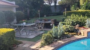 Ein Garten mit Pool, Terrassenmöbeln und verschiedenen Pflanzen.