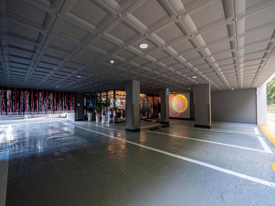 A spacious indoor area with a high ceiling, large windows, and a wet floor.
