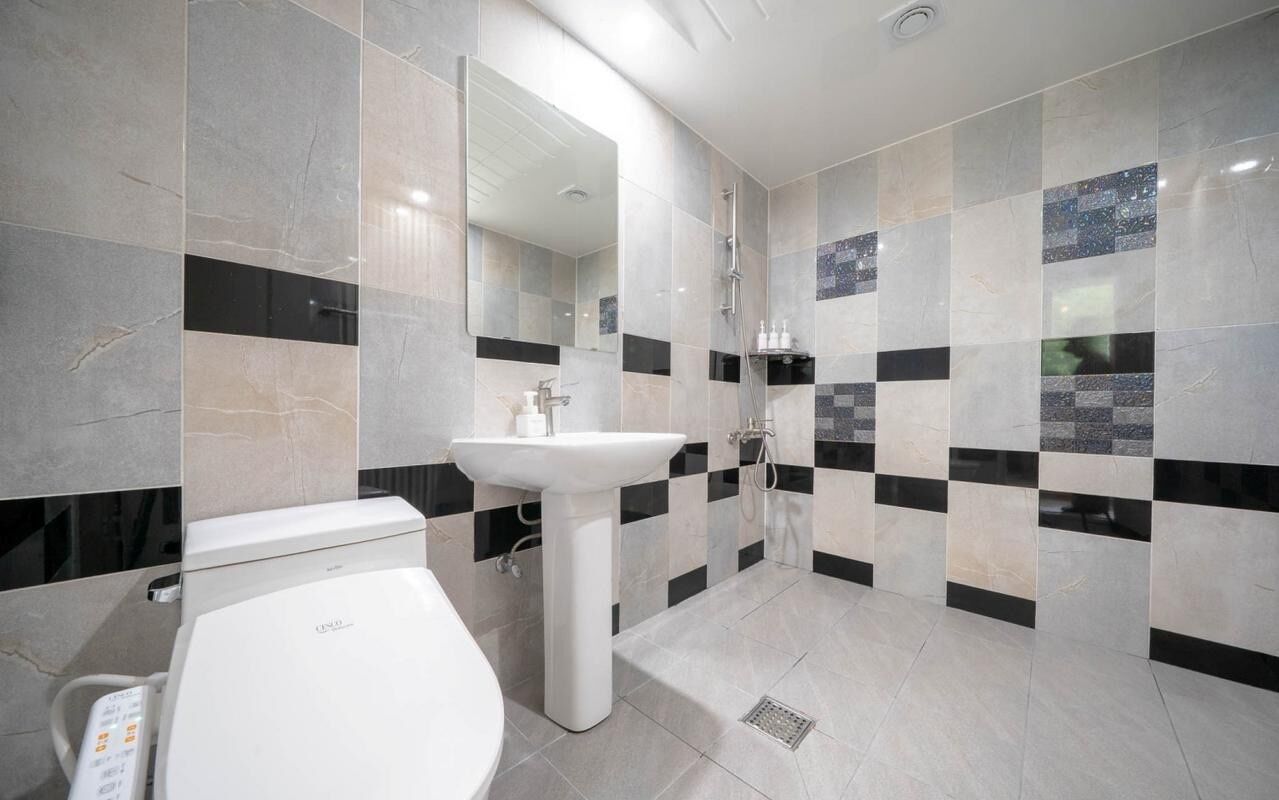 A modern bathroom with a toilet, sink, and shower.