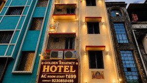 Un hotel con un cartel que indica 'Golden Regency Hotel' y 'Habitación AC desde ₹699'.
