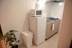 A compact kitchen with a microwave, stove, and sink. - Ashe Maison Tennoji West II (Osaka)