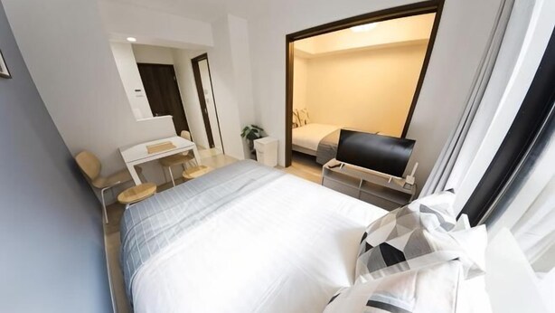 A modern hotel room with a bed, desk, chair, and a large window. - Ashe Maison Tennoji West II (Osaka)