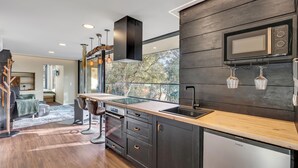 Una cucina moderna con piano di lavoro in legno, elettrodomestici in acciaio inossidabile e forno a microonde integrato.