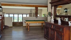 A spacious room with a pool table, wooden cabinets, and a large mirror. - Fat Mulberry Guest Farm (Fouriesburg)