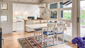 A kitchen with white cabinets, a wooden countertop, and a hanging pendant light.