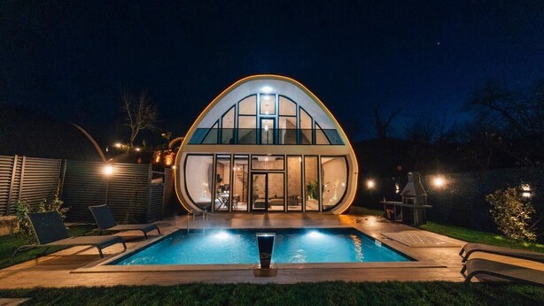 Una casa moderna con piscina, un patio cubierto y una zona de barbacoa.