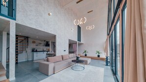 Un amplio salón con un sofá, una mesa de centro y una cocina al fondo.
