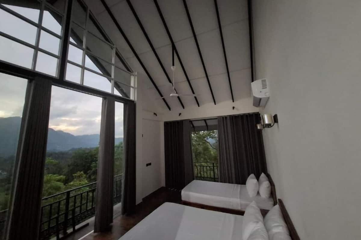 A hotel room with a large window, a balcony, and a bed.
